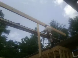 Carpenter setting a ridge beam over a new addition frame — Ice Dam Removal by Roofing Brothers in Mont Clare