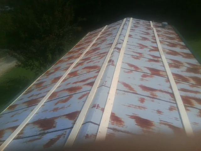 Rusted metal roof panels with new wood purlins before replacement — Storm Damage Roof Repair in Mont Clare by Roofing Brothers