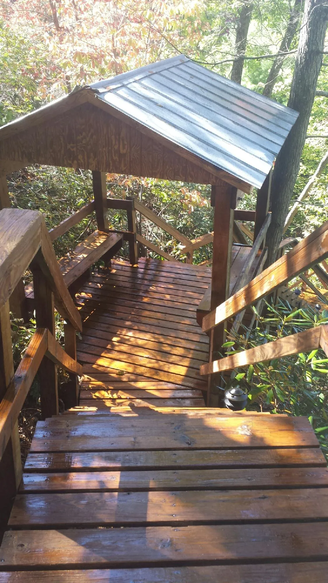Freshly stained wood walkway and covered shelter with a metal roof in Mont Clare