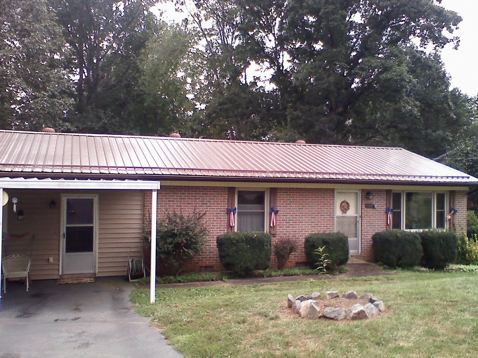 Bronze metal roof and carport on a brick ranch home — Roof Repair work by our crew in Mont Clare